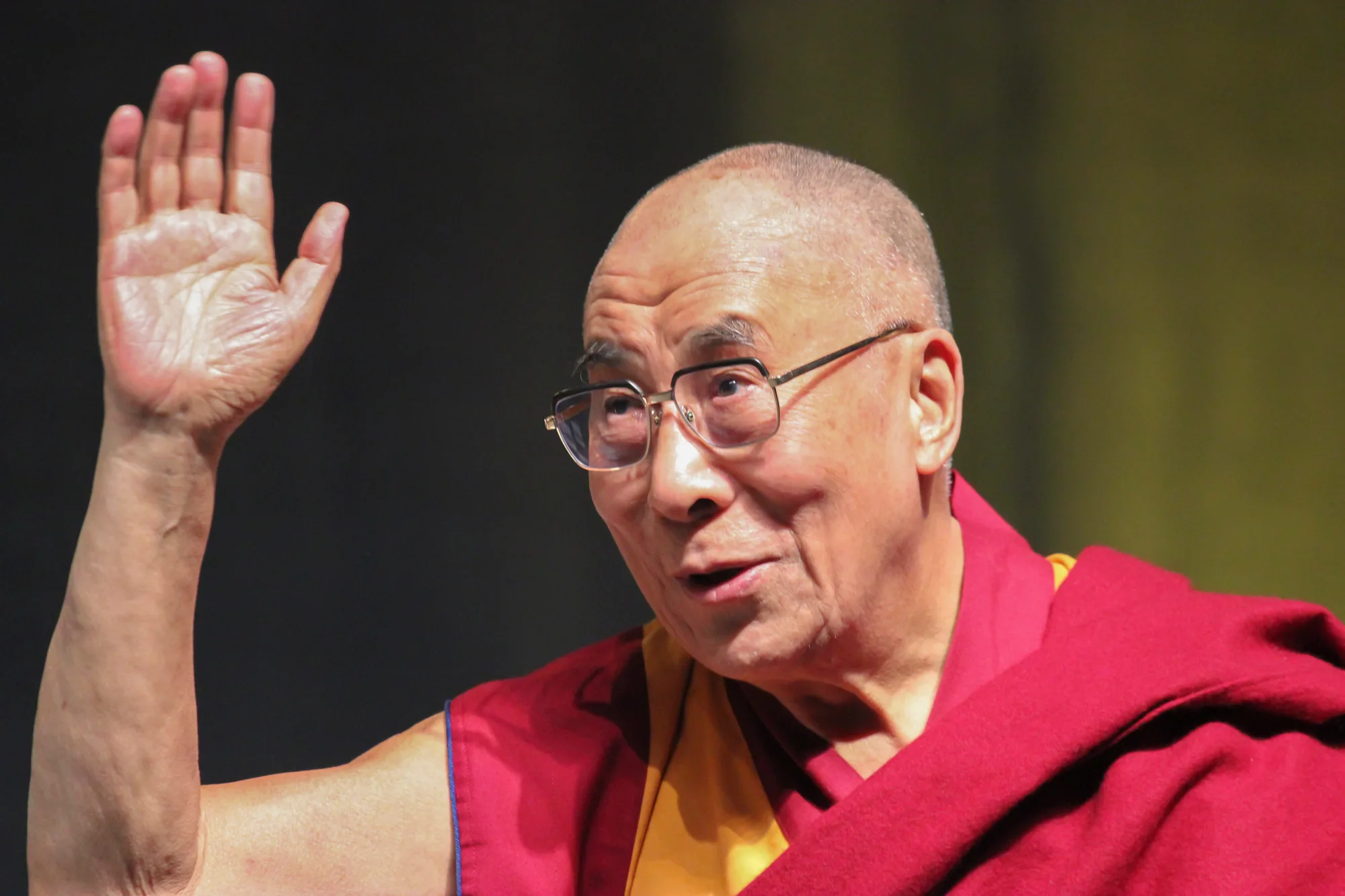 The Dalai Lama waves to a crowd of guests at the Providence Convention Center in Providence, RI.
