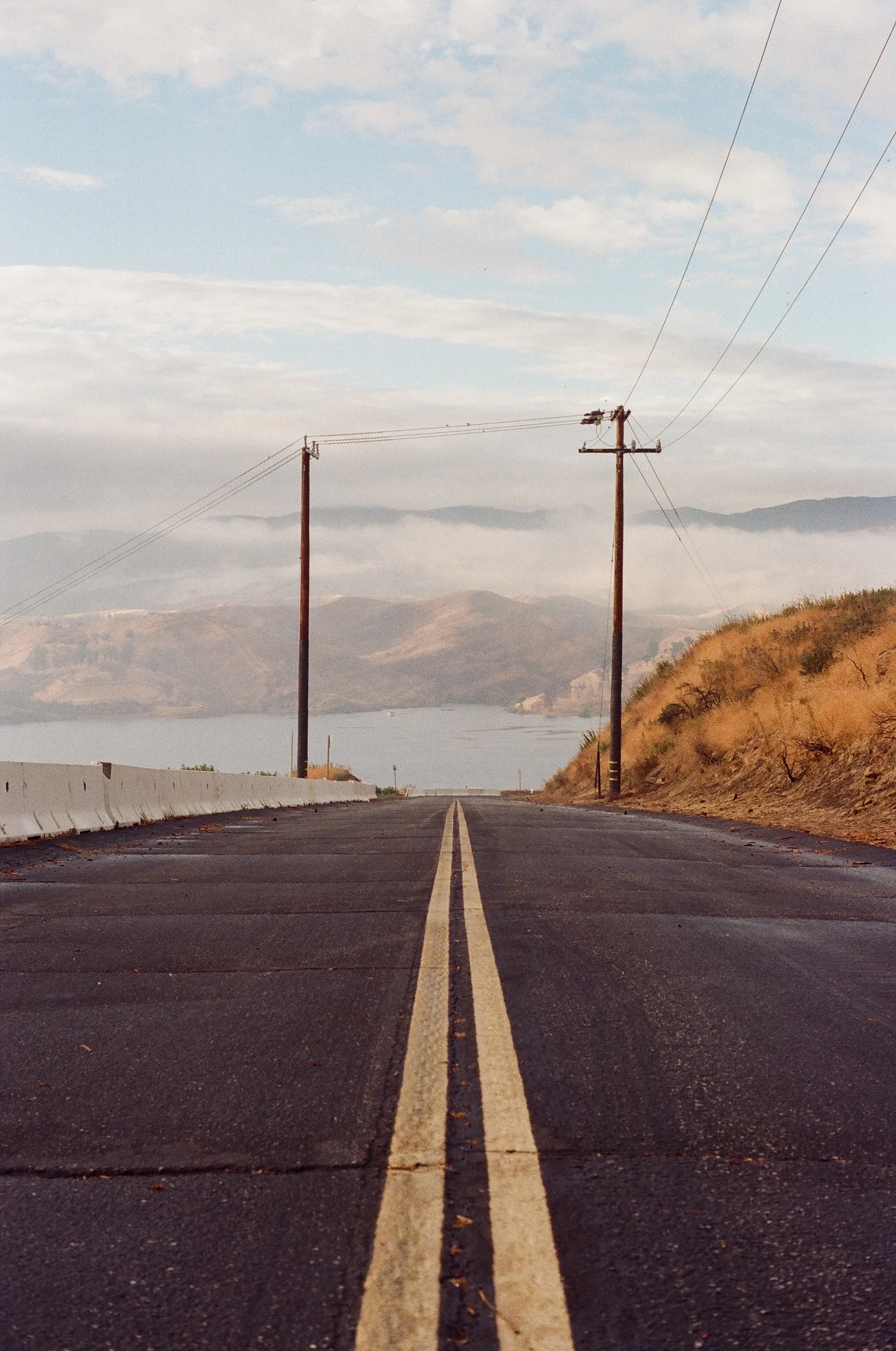 A road leading to a gloomy-looking lake.