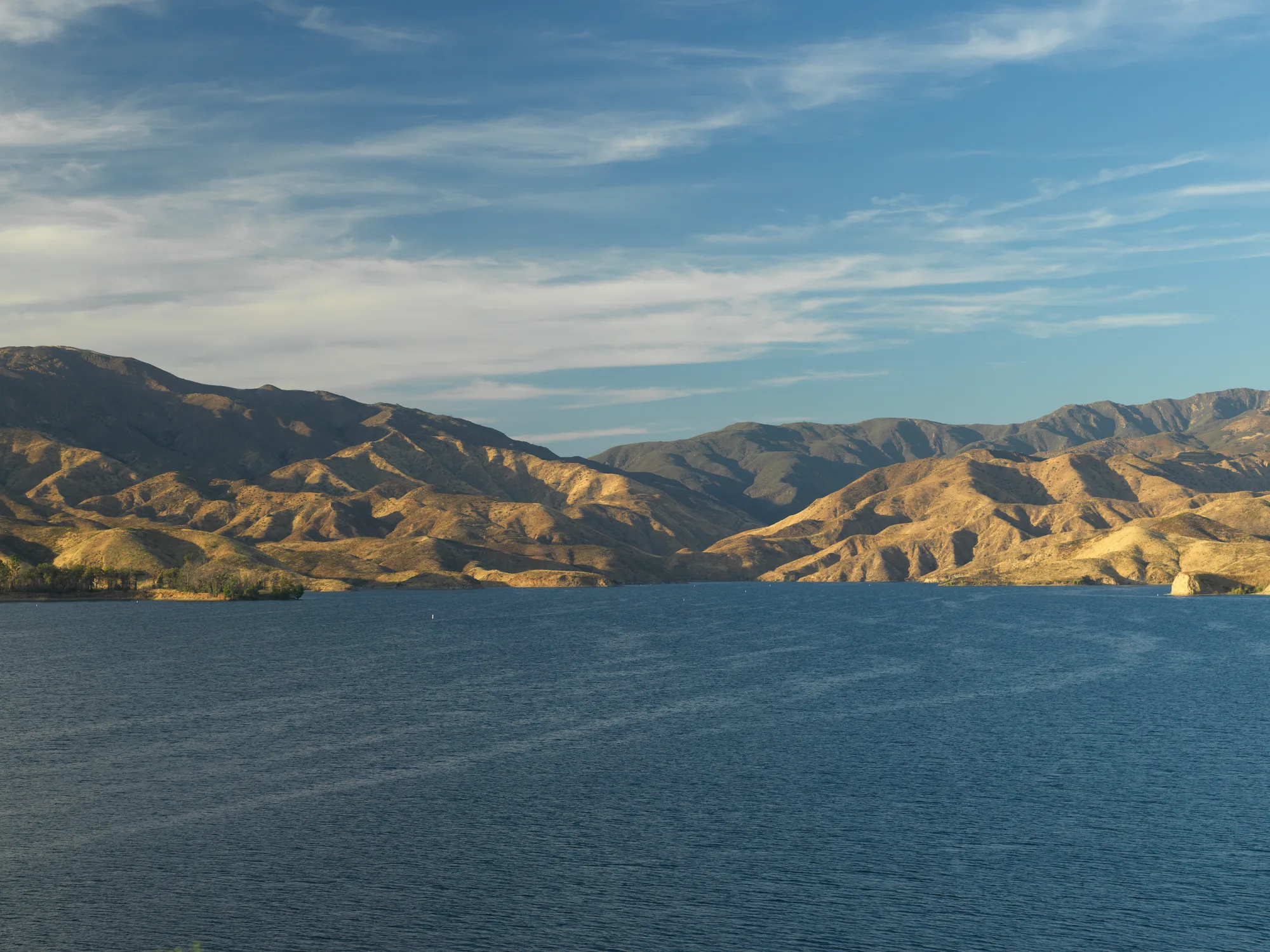 The California hills seen meeting a lagoon.